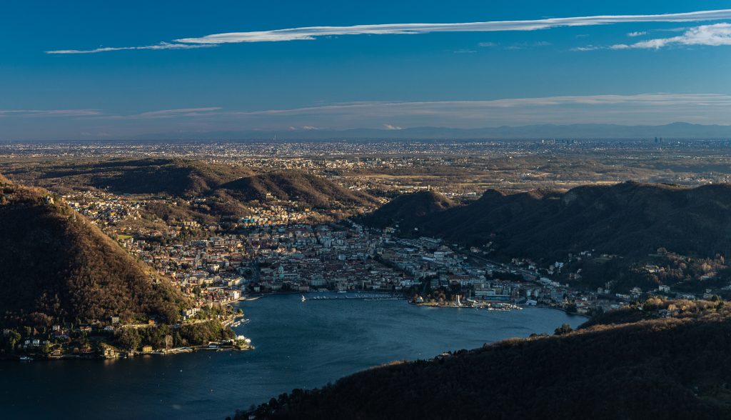 Como e il bacino meridionale del lago osservati dall’alto, con la pianura all’orizzonte.