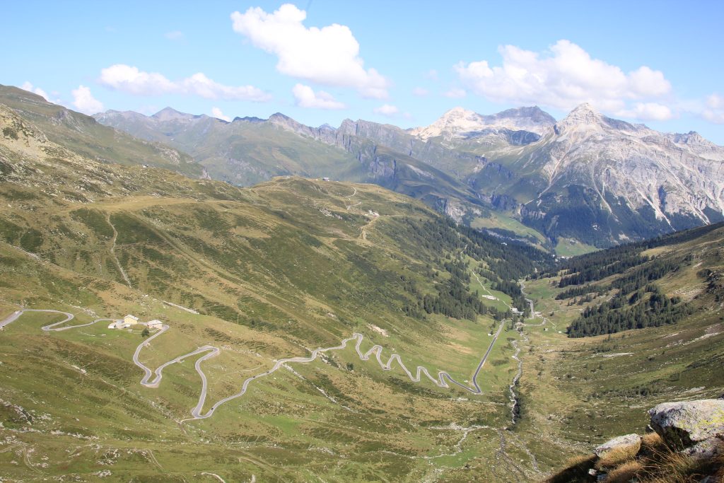 Tornanti del versante svizzero del Passo dello Spluga tra prati e montagne.